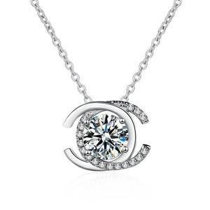 Macro shot of silver pendant featuring a brilliant round diamond in a C-shaped frame