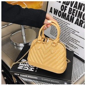Close-up of bright yellow jelly shell bag featuring V-shaped texture and gold metal chain
