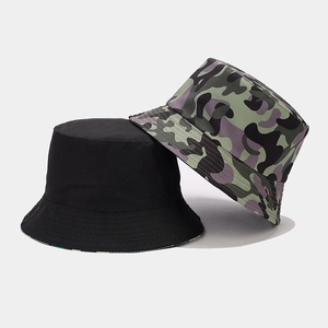 Detail of camouflage and black reversible bucket hats showing canvas texture and stitching