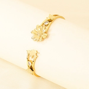 Gros plan détaillé du bracelet jonc doré motif marguerite et papillon avec pierres zircons