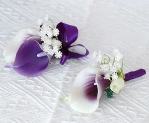 Close-up of purple calla lily and rose corsage with elegant satin ribbon bow detail