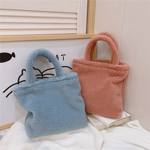 Dettaglio delle spesse borse tote in peluche blu e rosa con texture in ecopelliccia