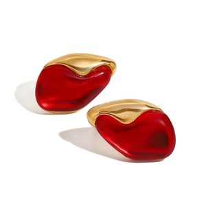 Artistic gold stainless steel earrings with irregular translucent red stones on white background