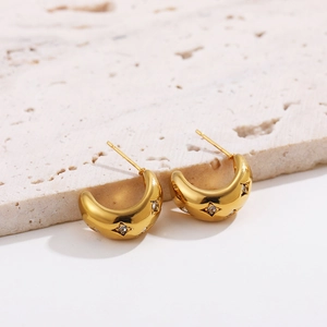 Close-up of 18K gold plated hoop earrings with star-engraved zircon on stone base