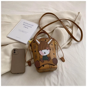 Brown bucket bag with 3D bunny doll, leather texture detail in a cozy lifestyle setting