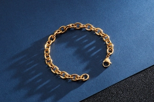 Detailed close-up of a gold-plated stainless steel oval link bracelet with lobster clasp