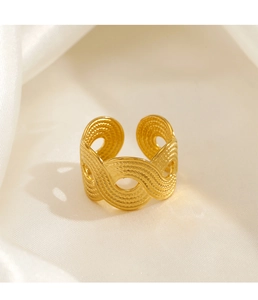 Detail of gold wave-textured open ring on white silk background with elegant lighting