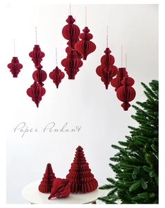 Macro detail of red paper honeycomb ornaments and holiday pendant for Christmas tree
