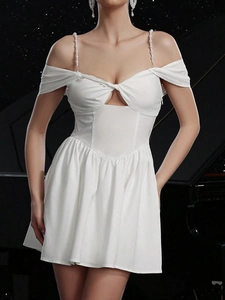 Elegantes weißes figurbetontes Kleid mit Perlenträgern und Ausschnitt vor schwarzem Grund