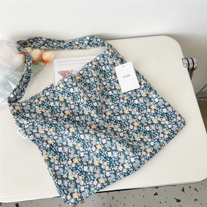 Detailed top view of a dark blue canvas bag featuring a delicate small floral dot pattern