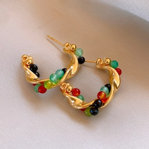 Detailed close-up of vintage gold twisted hoop earrings with red green and black beads