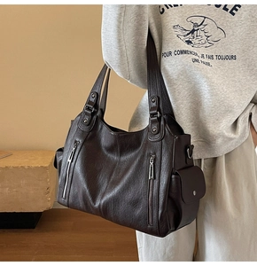 Side view of dark brown faux leather tote bag with rivets shown on a female model