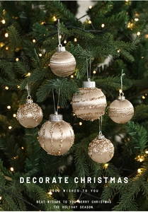 Detail of champagne gold Christmas ornaments with beads and sequins hanging on a tree