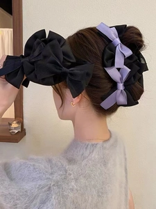 Elegant large bow hair claw clip in black and purple satin shown on female model