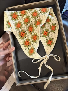 Detailed knit of a cream floral crochet bandana with orange and green flower patterns