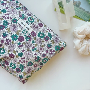 Detail of floral canvas toiletry bag with simple wish label and vintage flower pattern