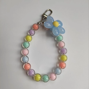 Macro shot of colorful pastel translucent beads with a blue floral pendant charm