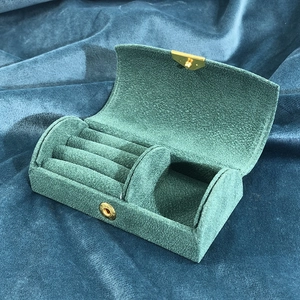 Detail view of the green velvet jewelry box with ring slots and golden snap fastener