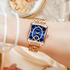 Close-up of elegant rose gold square watch with blue dial and diamond accents on a wrist