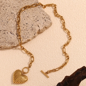 Gold plated stainless steel heart necklace with OT buckle on a natural stone background