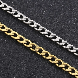 Detailopname van de zilveren en gouden titanium stalen Cubaanse schakelkettingen op zwart