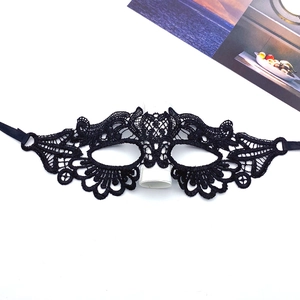Detailed view of black lace masquerade mask with intricate floral hollow-out patterns
