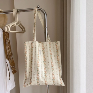 Close-up of floral stripe cotton tote bag with vintage woven label and shoulder straps