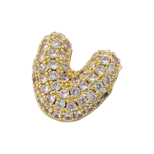 Macro shot of gold-plated U-shape bead accessory with clear cubic zirconia micro-pave setting