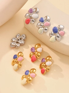 Dettaglio di orecchini in acciaio dorato 18k con design geometrico in smalto rosa acceso