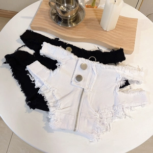 Detail der ausgefransten Kanten und des Doppelknopfverschlusses der Denim-Hotpants