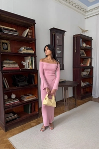 Detail of pink off-shoulder knitted dress and skirt set in a classic library setting
