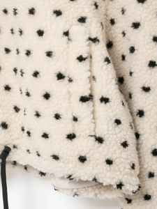 Détail de la veste en polaire à pois avec ourlet à cordon et poche latérale