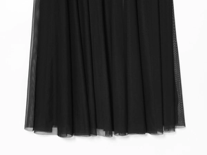 Detail of multi-layered black mesh hemline with sheer texture on elegant long dress