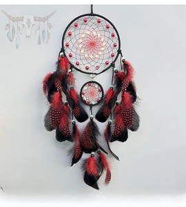 Detailed view of double-ring dreamcatcher with black feathers and red bead accents