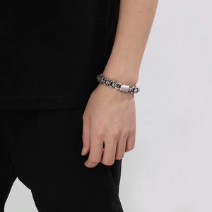 Close-up of vintage silver skull charm bracelet in punk style worn on a wrist