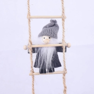 Detail of wool felt Christmas gnome with wood beads climbing on a rope ladder