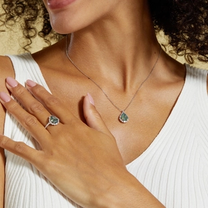 Detail of S925 silver necklace and pear-cut green moss agate ring worn by a model