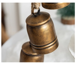 Macro shot of vintage bronze metal bells with rustic texture and natural hemp rope