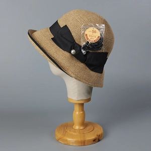 Women's woven straw sun hat with black satin bow and UPF 50+ protection for beach