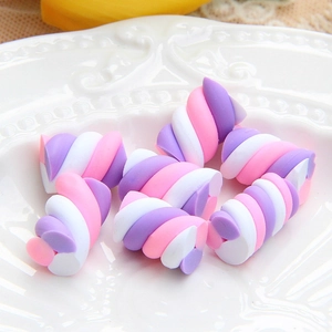 Macro view of purple and white spiral marshmallow clay charms on a white plate