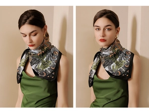 Detail view of floral print silk scarf with black borders on female model in green top