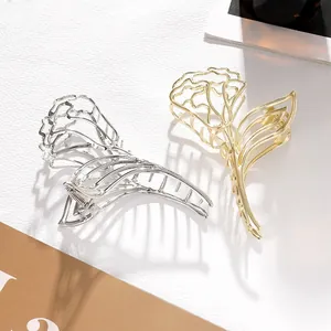 Detail of elegant hollow rose metal hair claws in polished gold and silver finishes