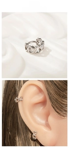 Detailed view of silver heart cartilage hoop earrings and ear cuff on a model