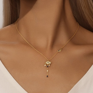 Detail of 925 sterling silver celestial necklace with moon and planet charms on a model