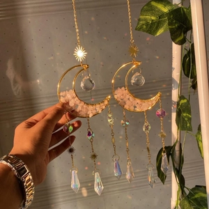 Close-up of golden moon suncatcher with pink crystals and rainbow prism pendants