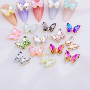 Detalle macro de dijes de mariposa de cristal 3D para uñas con base de metal dorado