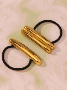 Detailed view of high-elasticity hair ties with gold geometric metal accents on marble