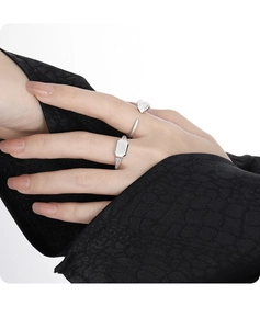 Close-up of minimalist S925 sterling silver heart and rectangular open rings on a hand