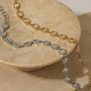 Chic gold and silver stainless steel bracelets with oval zircons on marble display