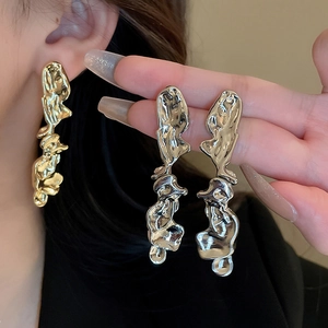 Detailed view of liquid metal irregular earrings in both gold and silver finishes
